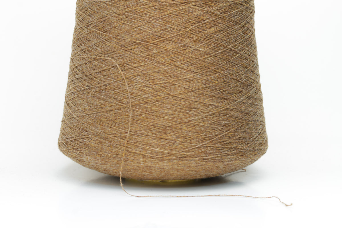 Close-up of a perfectly twisted two-ply cashmere yarn in a rich, warm brown shade, exhibiting a subtle natural sheen and delicate fluffiness.