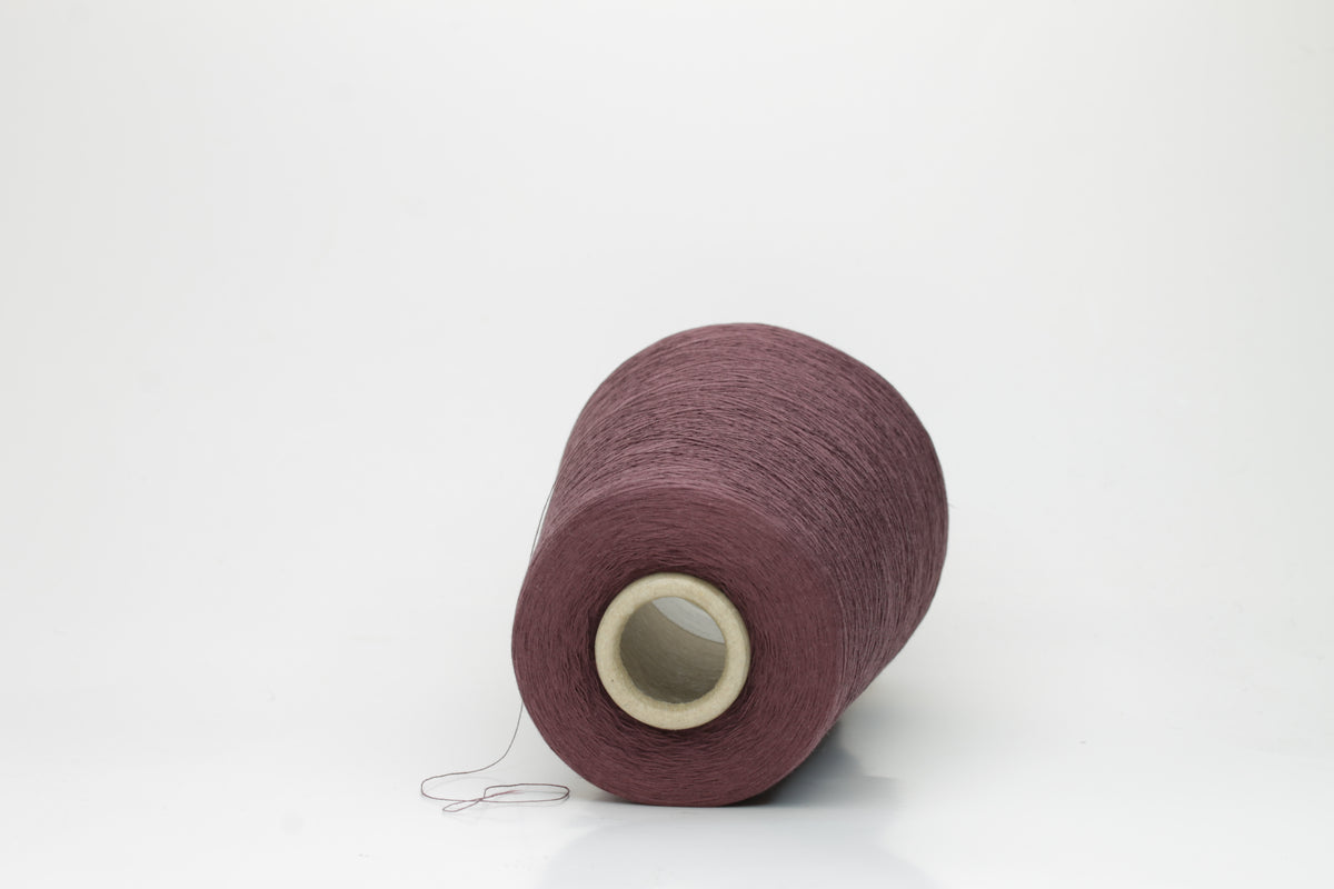 A finely spun, smooth cotton yarn, tightly plied, showcasing a muted, elegant dusty violet taupe color with a subtle matte sheen. No visible fluff.