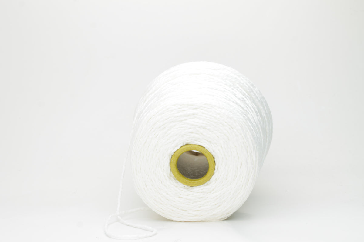 Close-up of a pristine white, single-ply cotton yarn with a smooth, even texture and subtle matte sheen, gently coiled.