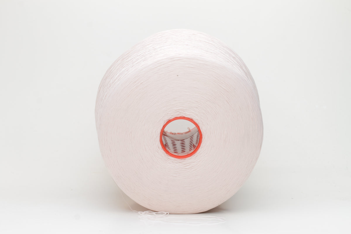 Close-up of a smooth, twisted, three-ply premium nylon yarn in a soft, elegant rose pink shade, exhibiting a subtle sheen and consistent strand structure.