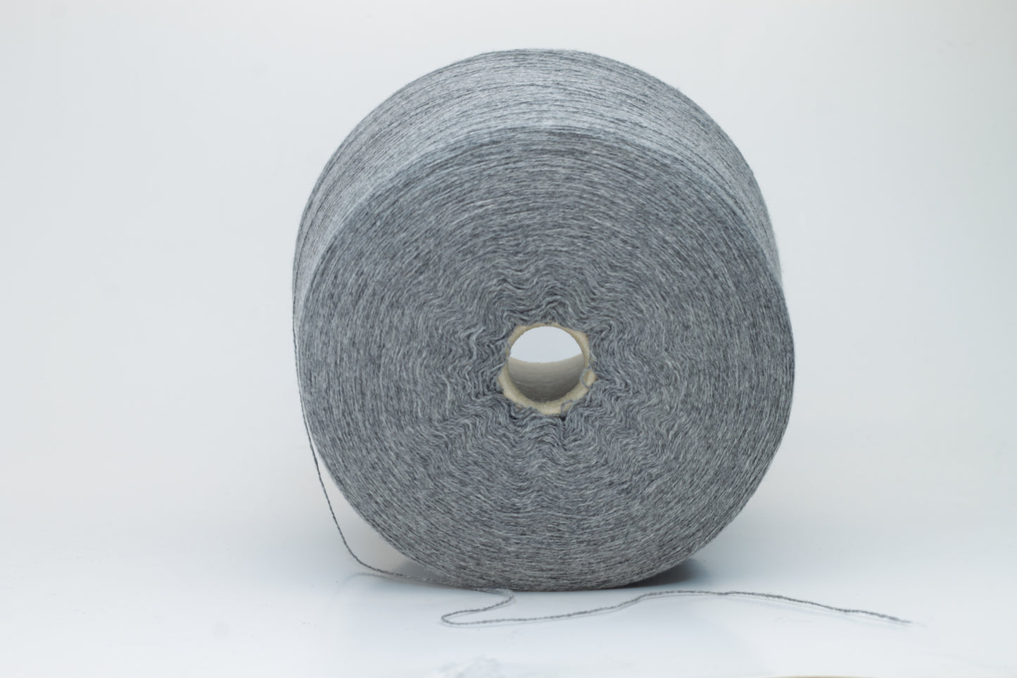 Skein of fine, two-ply cashmere yarn in a sophisticated medium gray, exhibiting a soft, subtle halo and delicate matte sheen.