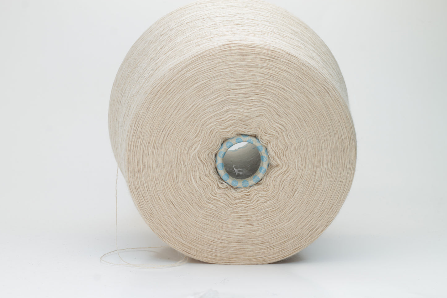 Close-up shot of creamy beige merino yarn, featuring a tight ply twist and a subtle sheen. The fibers exhibit exceptional fluffiness and texture, ideal for intricate knitting patterns.