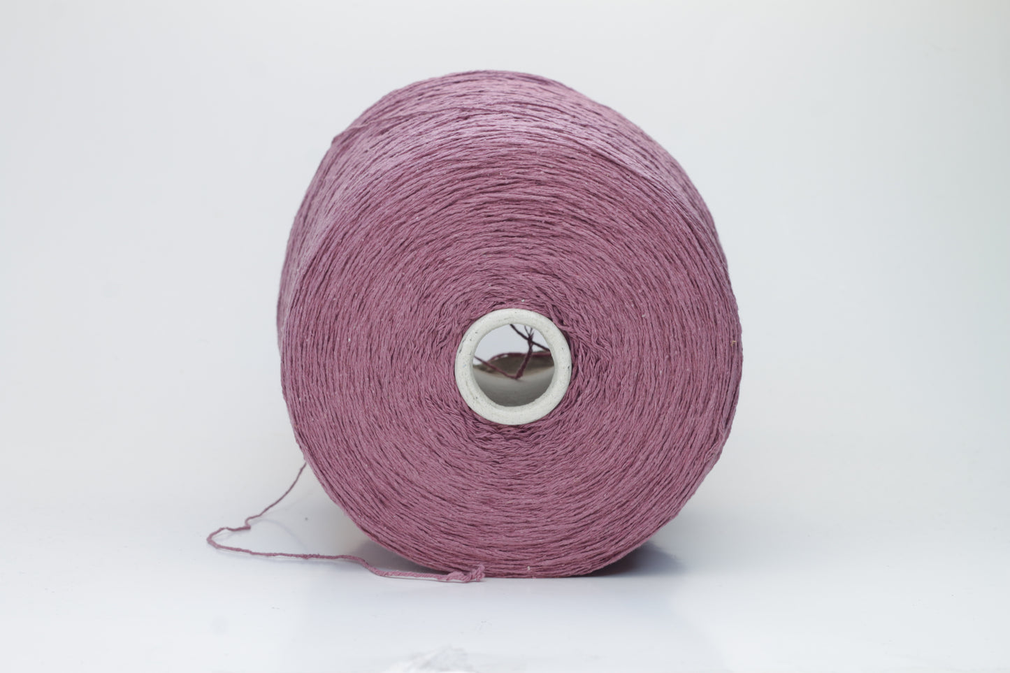 Close-up image of the burgundy silk bourette yarn, showcasing a dense ply twist and subtle sheen. The yarn appears incredibly soft and fluffy with rich color depth.