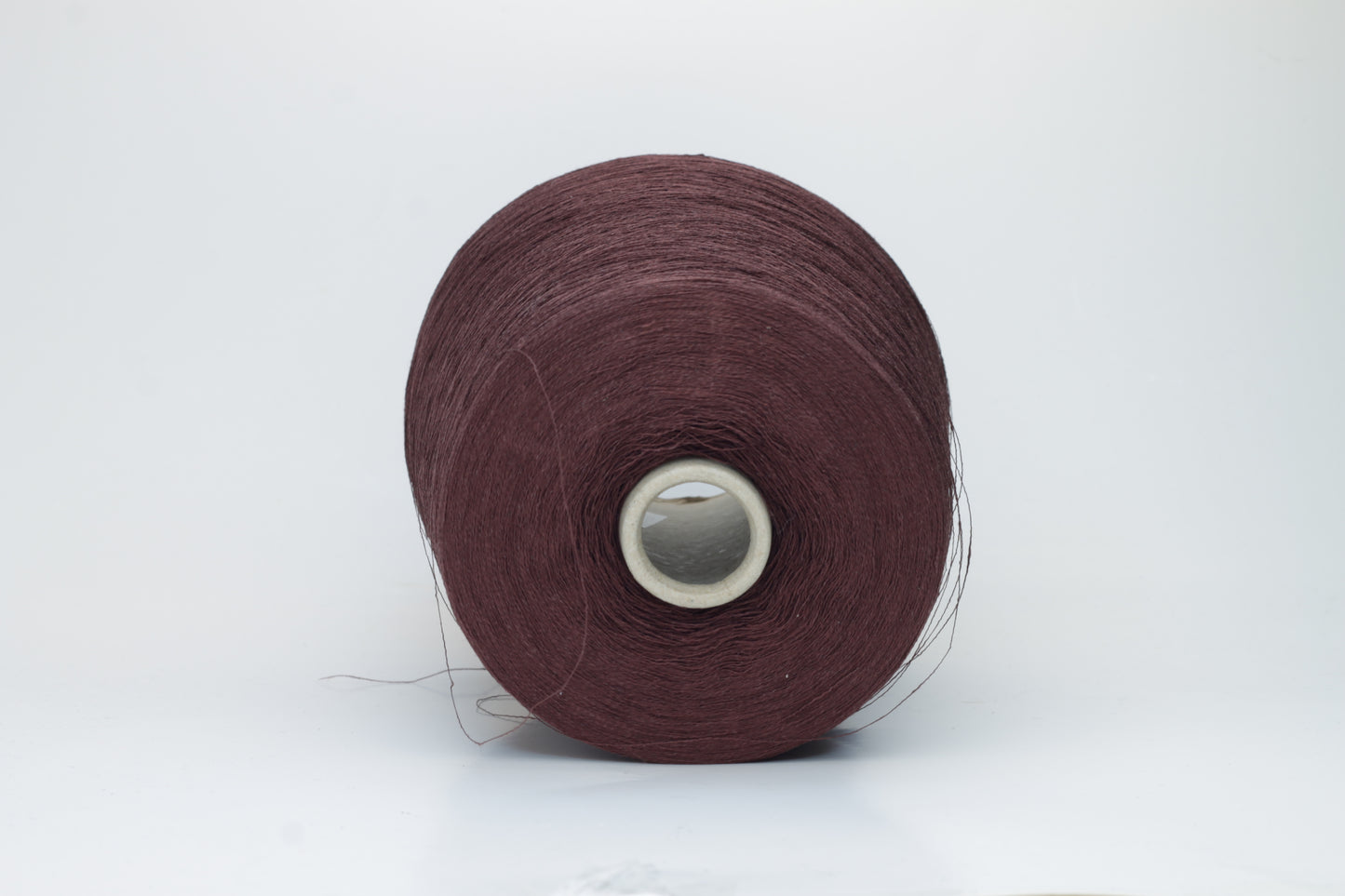 Close-up of a tightly twisted, fine-gauge yarn in a deep, warm earthy brown color, showing a subtle natural sheen from the linen fibers.