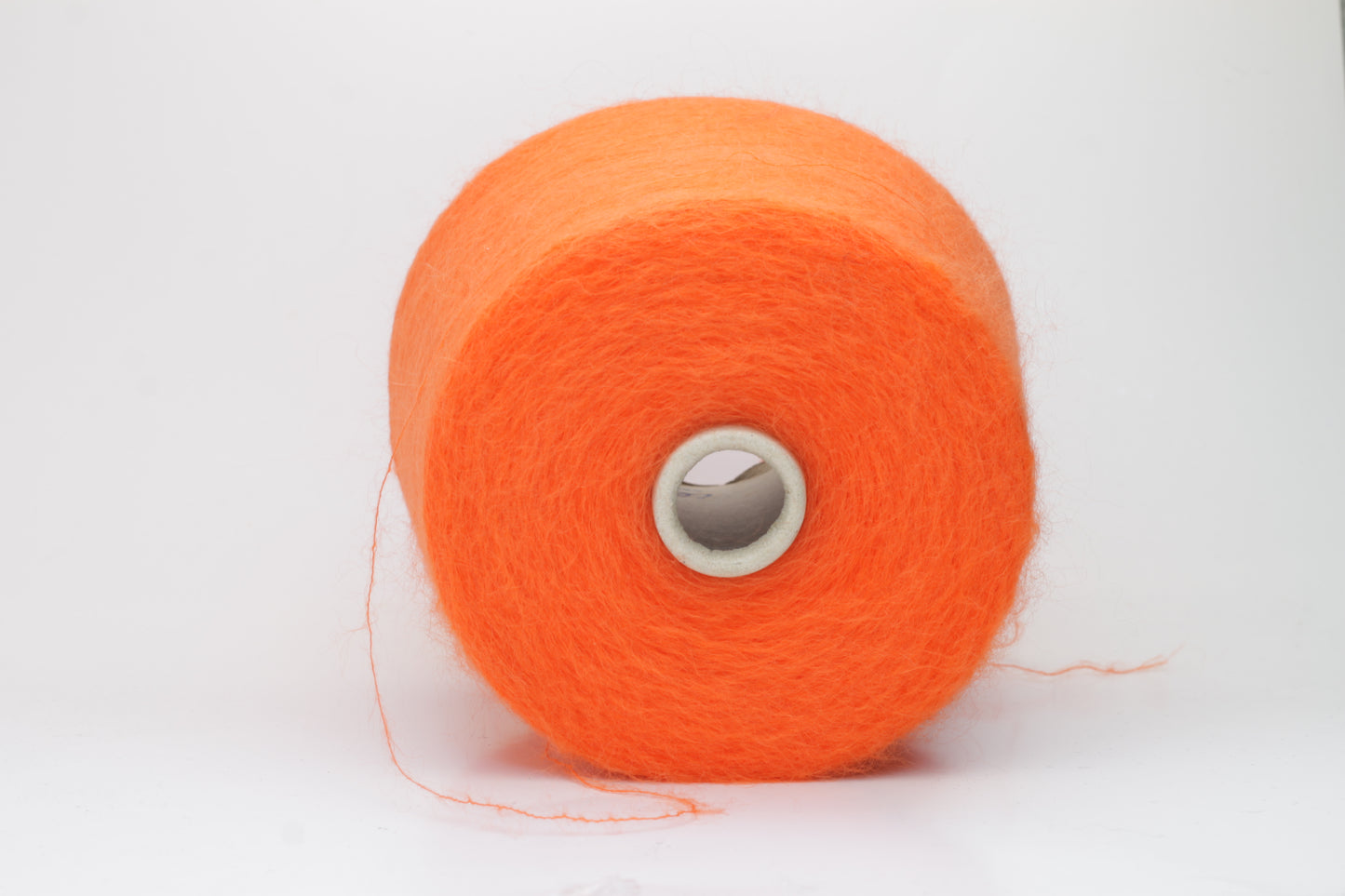Close-up shot of vibrant orange SuperKidMohair yarn, displaying a tight ply twist and a rich, fluffy texture with noticeable sheen.