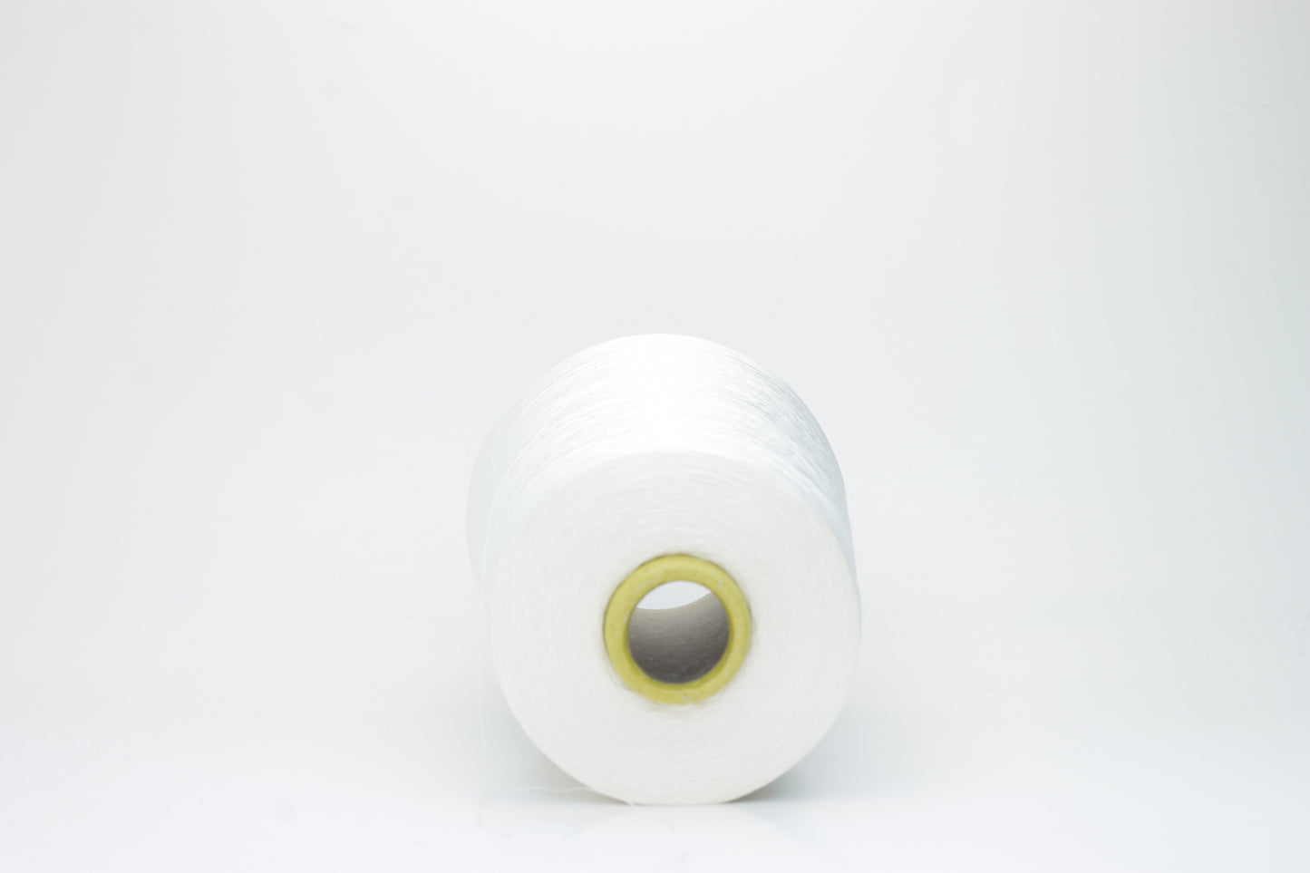 A close-up of premium 100% silk yarn, tightly plied, displaying a smooth, lustrous surface and a warm, creamy latte beige color.