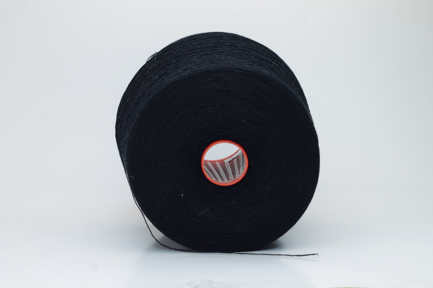 Close-up of a deep black, two-ply cashmere yarn, exhibiting a soft, even twist and a subtle, rich sheen under natural light, indicating its luxurious texture.