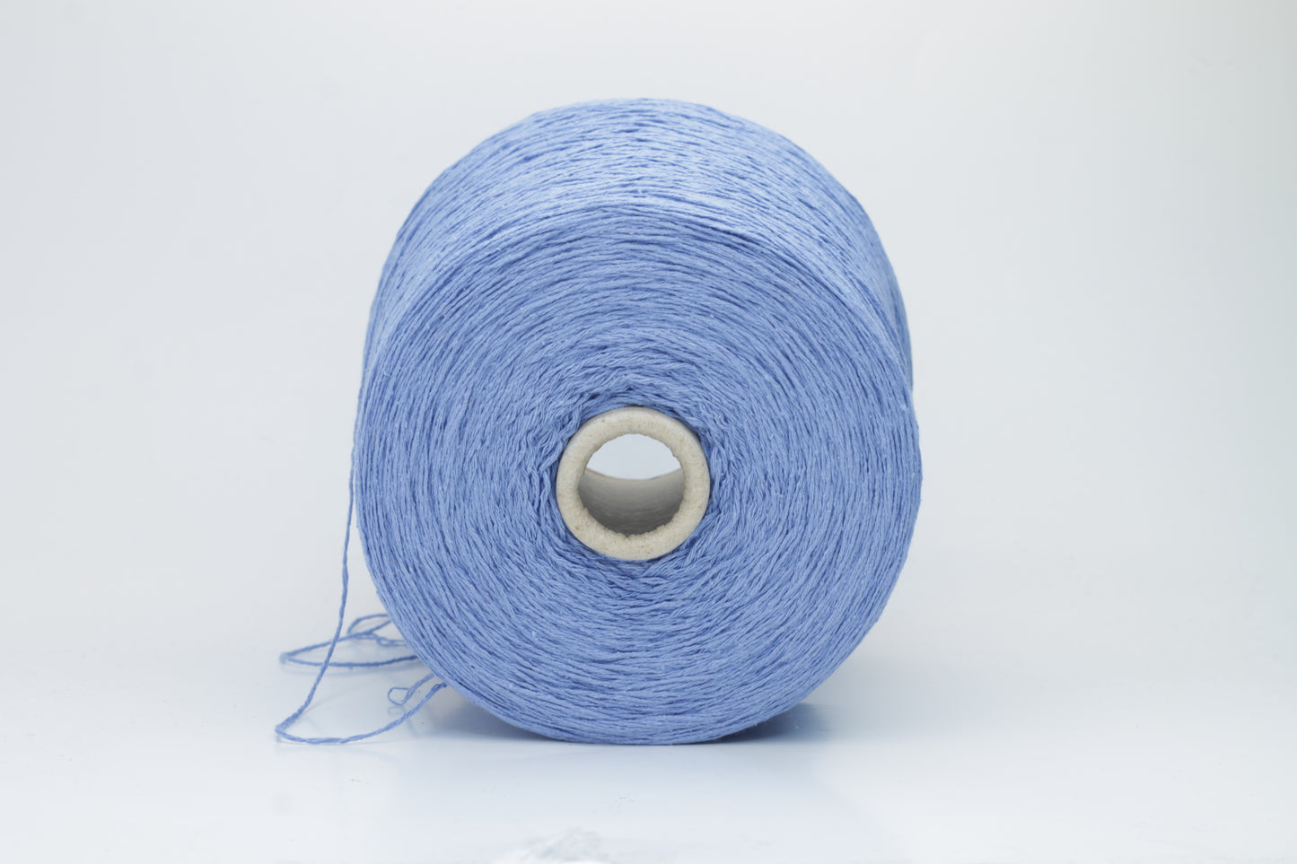 Close-up of a skein of deep Blue bourette silk yarn, showing its characteristic subtle slubs and matte texture, with a gentle, soft twist.