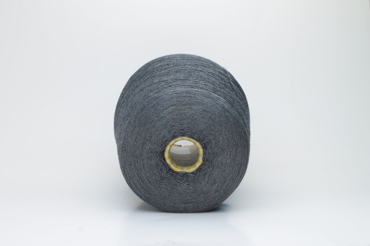 Close-up of a finely spun, lustrous dark gray silk yarn, exhibiting a smooth surface and a subtle sheen. The tightly twisted plies are visible, creating a refined, consistent thread structure.