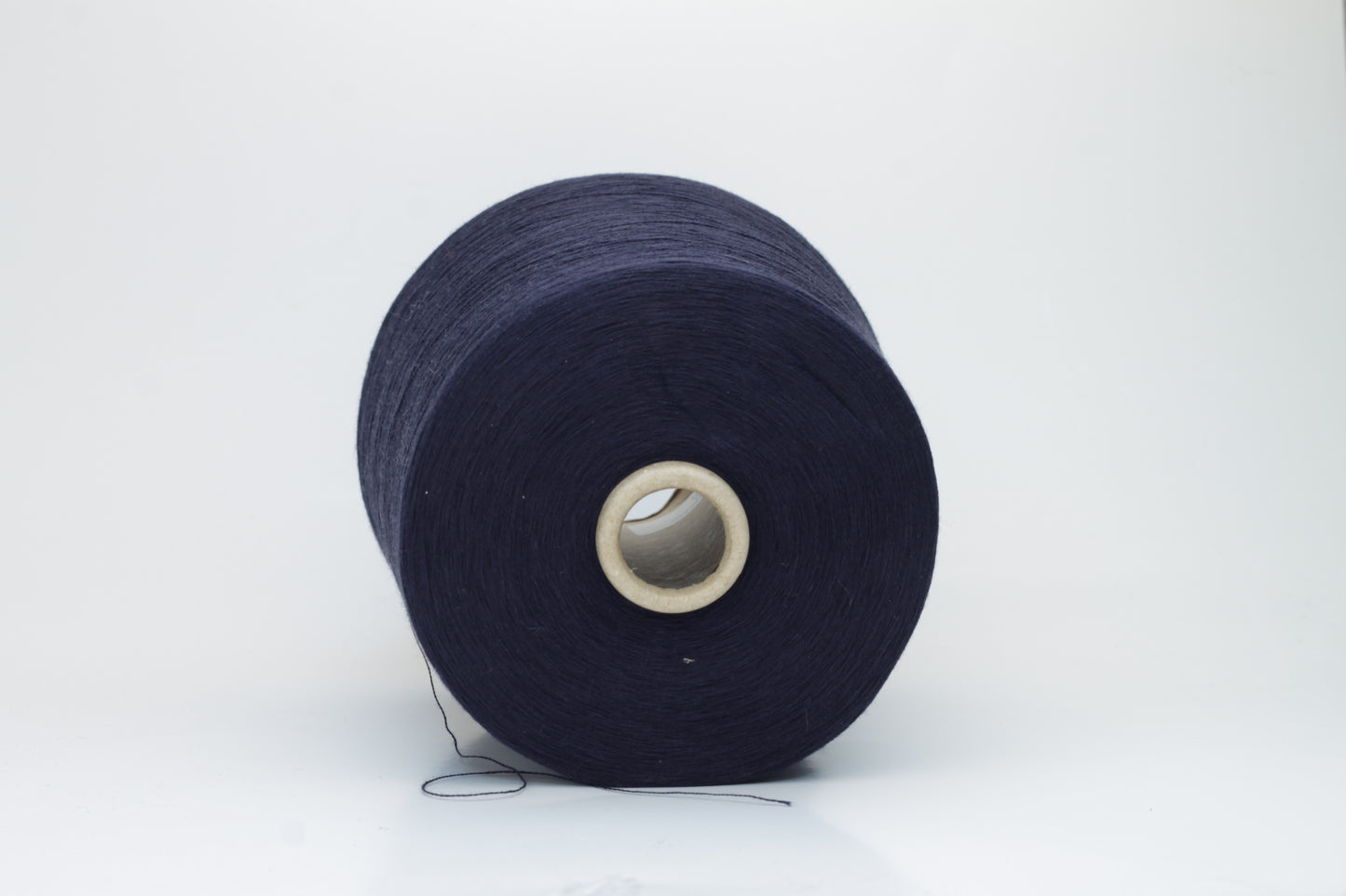 Close-up shot of dark blue, fluffy cotton 85% cashmere 15% yarn in a twisted ply, showcasing the fine thread structure and subtle sheen.