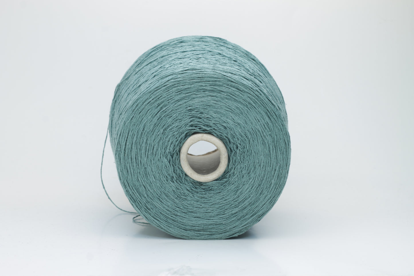Close-up shot of shimmering silk bourette yarn in a rich verdone color. The multi-plied strands show subtle twist and depth, with a delicate sheen and fluffy texture.