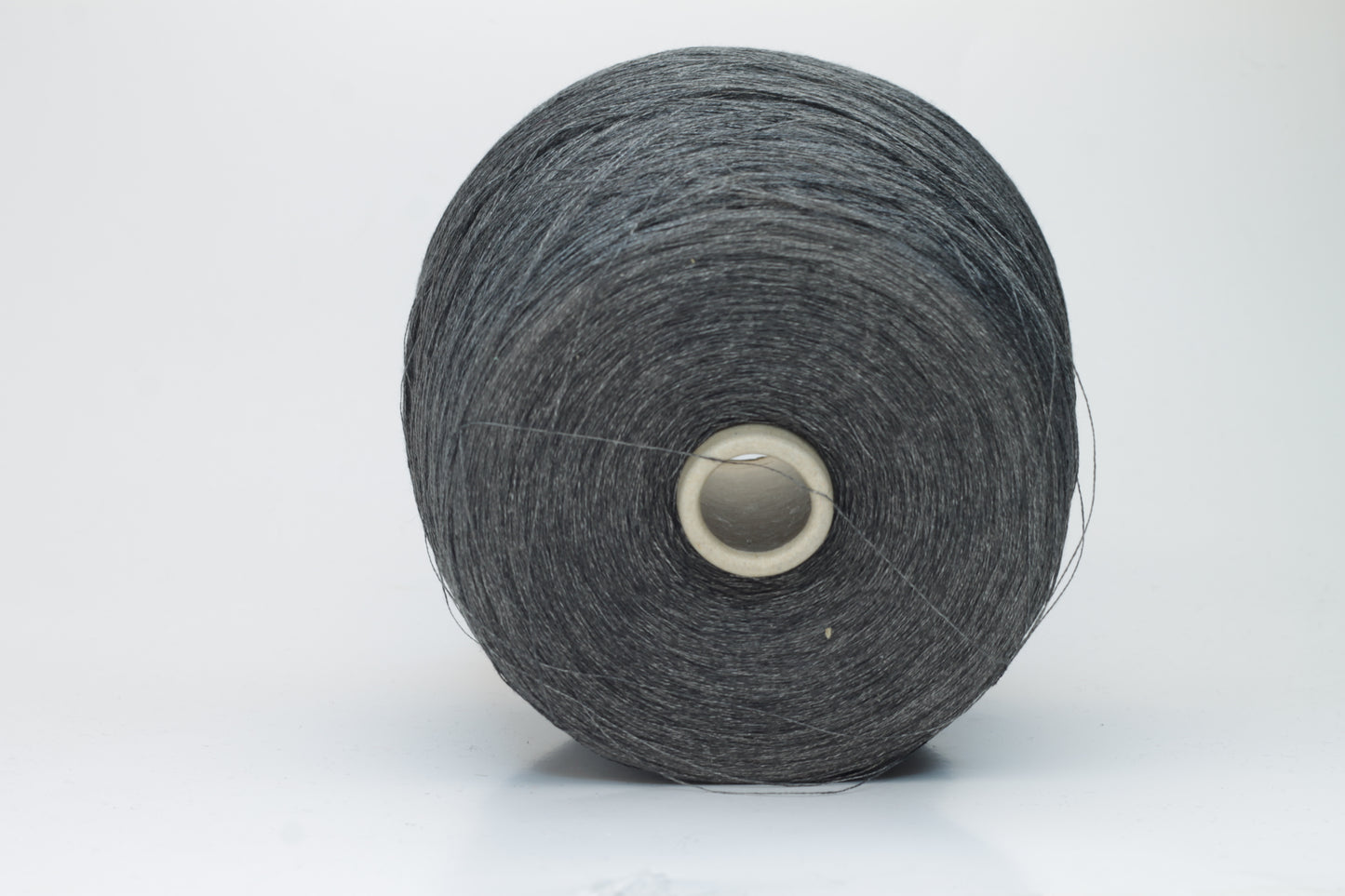 Close-up of a neatly wound skein of fine, smooth brownish-grey linen yarn, exhibiting subtle natural slub variations and a gentle matte sheen.