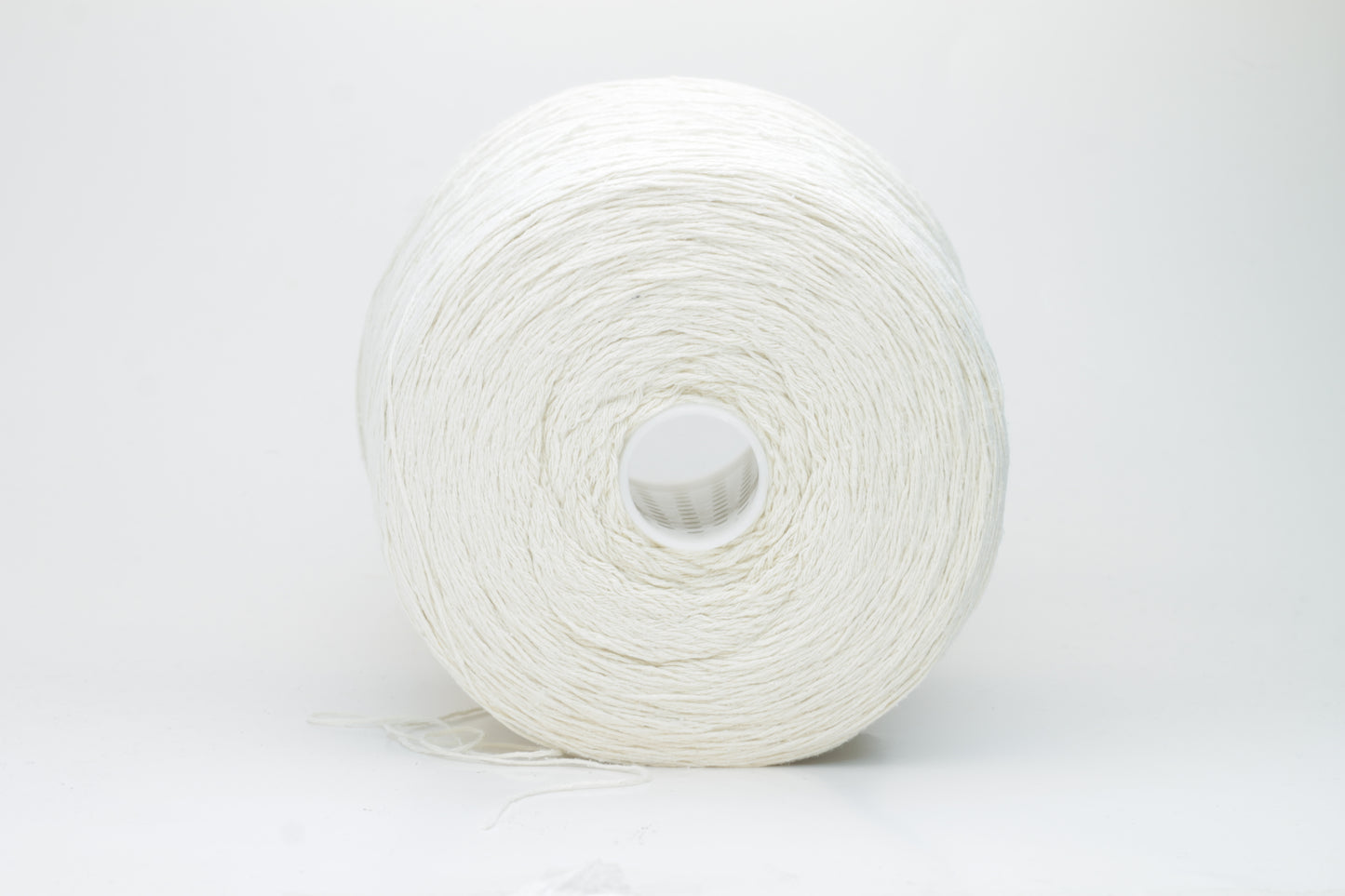 Close-up shot showcasing the fluffy, lustrous sheen of white silk bourette yarn in a single ply twist. The thread structure is clearly visible with subtle variations in color depth.