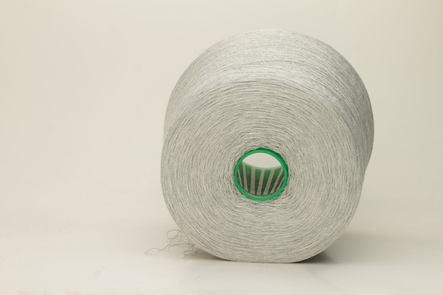 Close-up of a smooth, tightly plied gray yarn skein with a subtle, refined sheen, showcasing the luxurious blend of silk and cotton fibers.