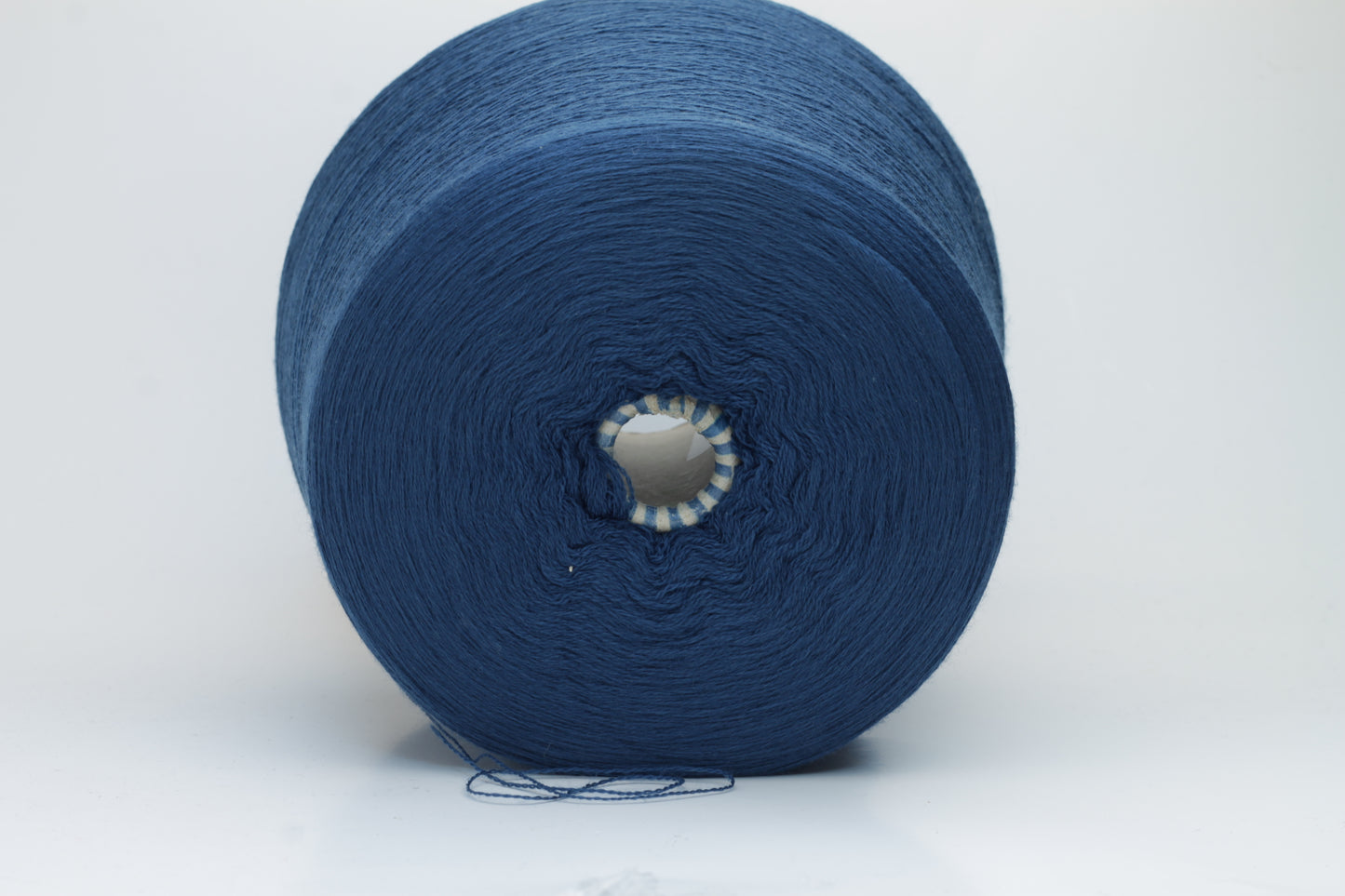 Close-up view of ZEGNA BARUFFA Merino 100% Cashwool, Nm 2/30, Color Blue. The yarn showcases a tight, even ply twist with a dense thread structure and subtle sheen reflecting the deep blue color, presenting a fluffy and inviting texture.