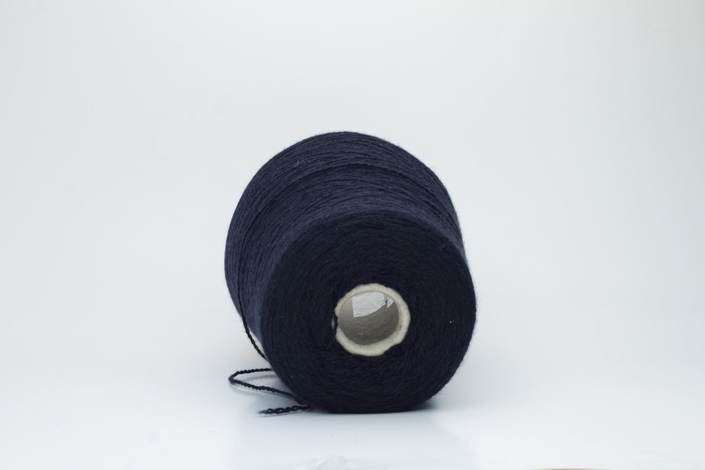 Luxurious, evenly spun two-ply yarn in a deep, rich matte navy blue. The cashmere fibers exhibit a soft halo and subtle natural sheen.