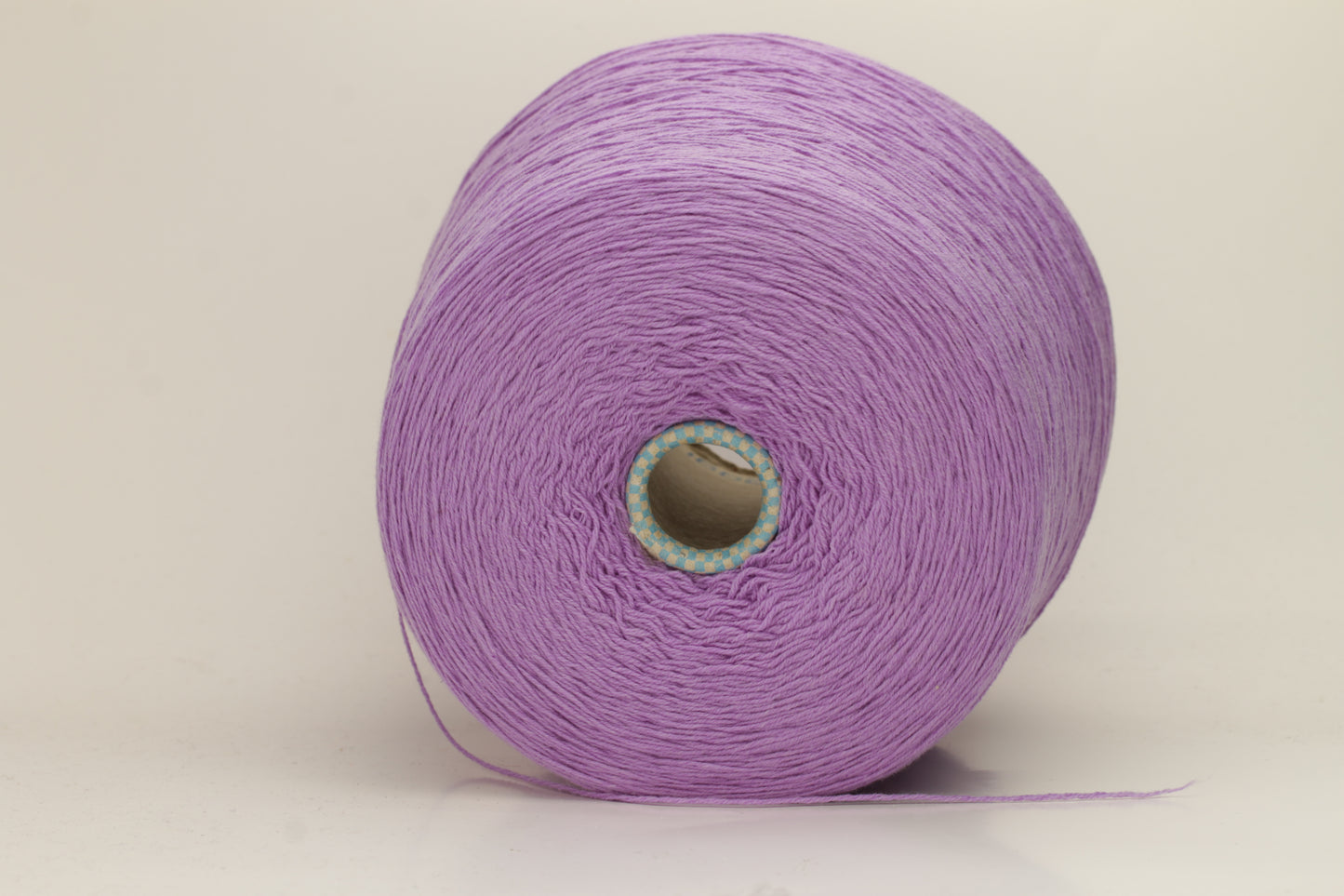 Vivid royal purple cashmere yarn, softly coiled, showcasing its fine 6-ply twist and subtle lustrous sheen, ideal for luxury textiles.