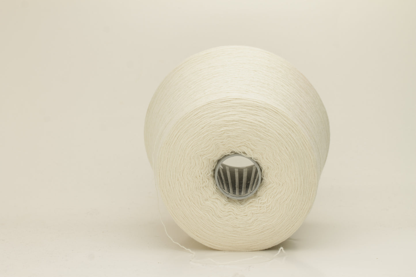 Close-up of a skein of pristine Ice White 100% cashmere yarn, showcasing its fine, evenly plied two-ply structure and delicate, soft halo.