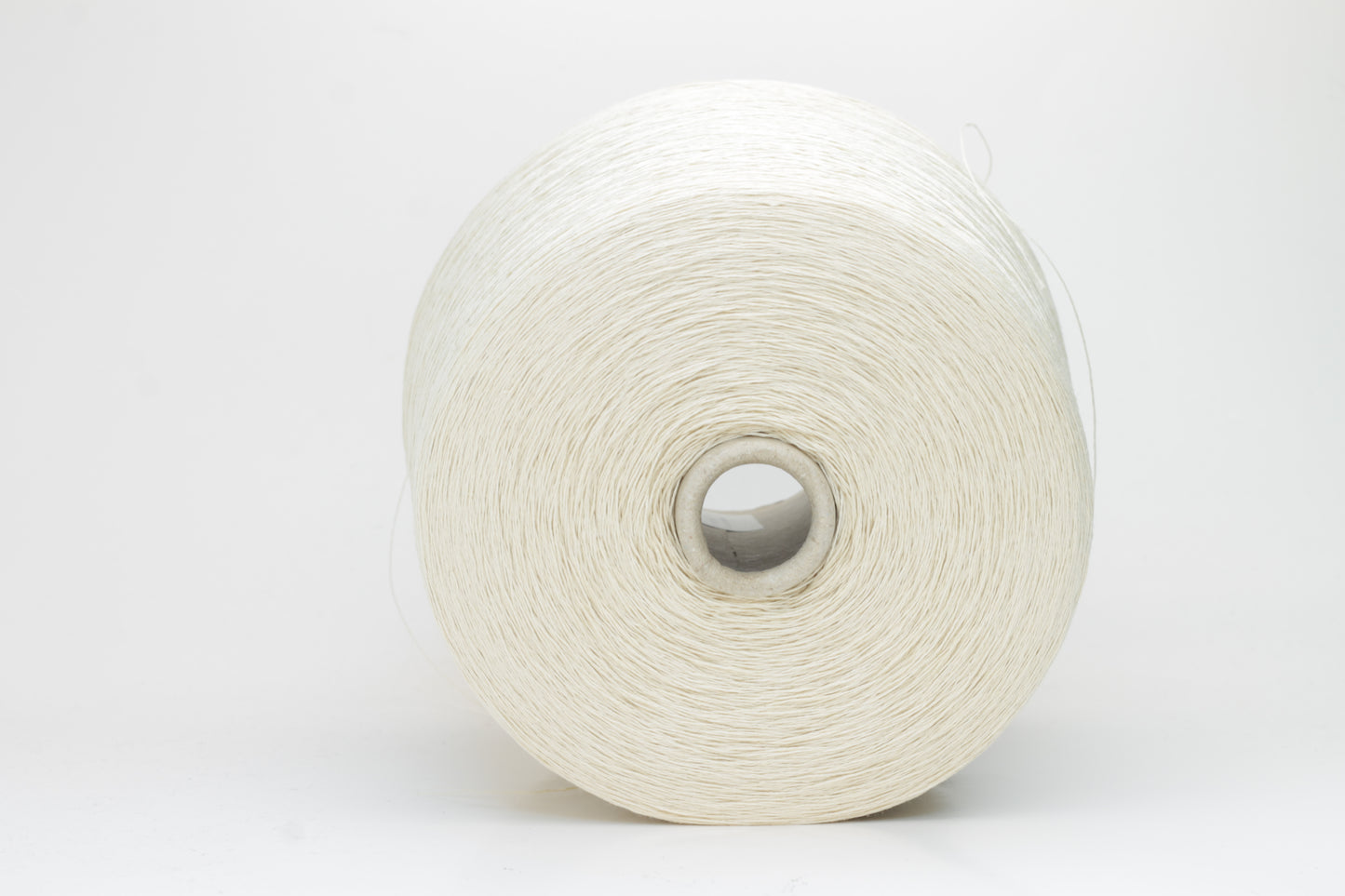 A soft light beige three-ply linen yarn, tightly twisted with a subtle natural sheen, presented in a neatly wound skein, showcasing its crisp, cool texture.