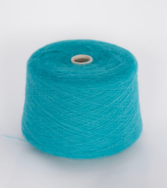 Close-up image showcasing a cone of dark cyan kid mohair yarn, revealing its fluffy texture, subtle sheen, and the complex ply twist of the fibers creating a rich, vibrant color depth.