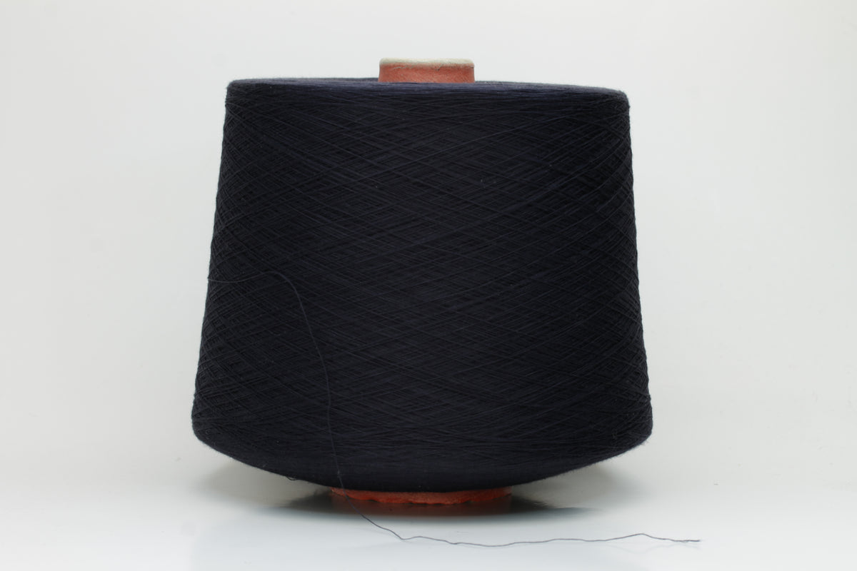 A skein of finely spun, smooth 100% cotton yarn in a deep Midnight Navy, showing a subtle sheen and even, uniform twist.
