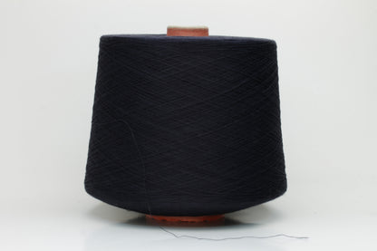 A skein of finely spun, smooth 100% cotton yarn in a deep Midnight Navy, showing a subtle sheen and even, uniform twist.