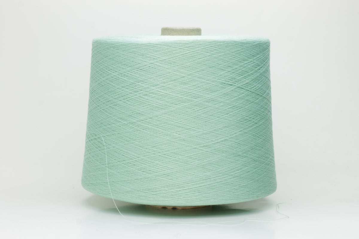 A finely spun, smooth cotton yarn in a delicate pastel mint green color, showing a subtle sheen and tightly plied structure.