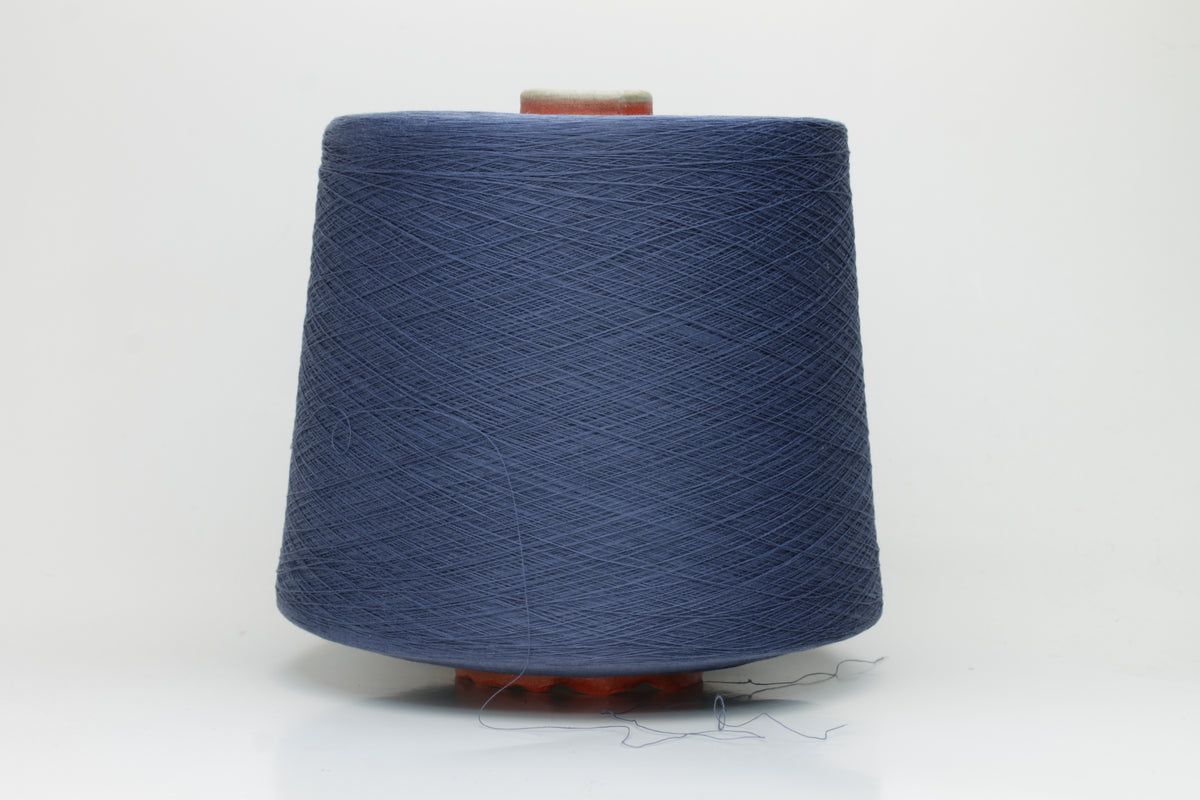 Close-up of finely spun, matte-finish cotton yarn in a rich, multi-toned classic denim blue heather, revealing subtle variations and a smooth, consistent two-ply twist.