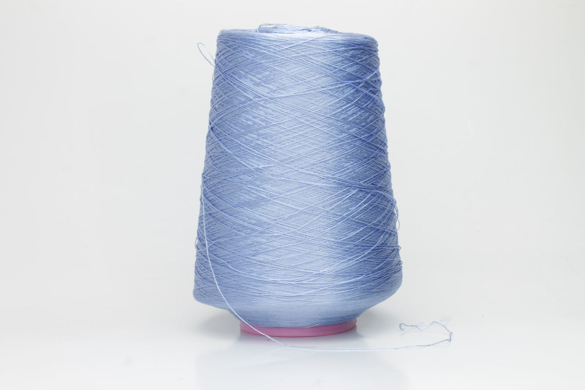 Close-up of extremely fine, single-ply pure silk yarn in a pale, iridescent sky blue. It has a high natural sheen and smooth, uniform texture.