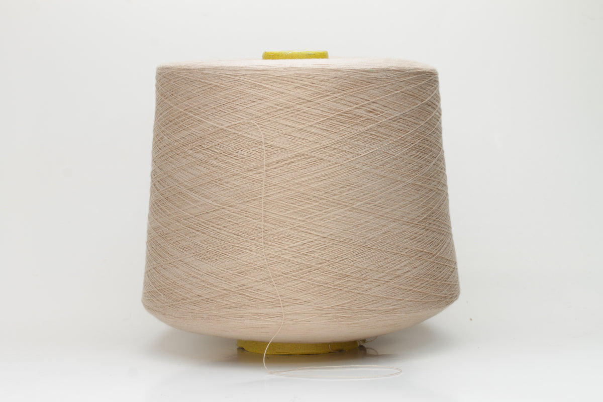 Close-up of a vibrant, Powder Pink Beige cotton yarn. The smooth, tightly twisted 2-ply thread exhibits a subtle sheen and deep, saturated color.