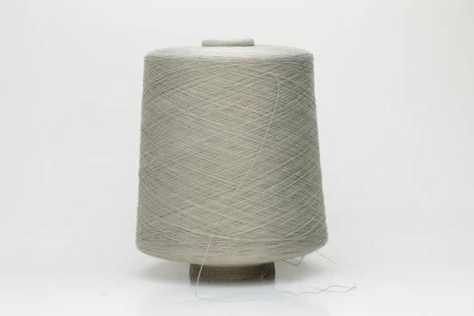 Close-up of a vibrant, Pale Sage Gray cotton yarn. The smooth, tightly twisted 2-ply thread exhibits a subtle sheen and deep, saturated color.