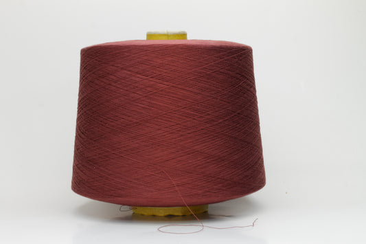 Close-up of a spool of Dusty Brick, smooth, 4-ply 100% cotton yarn with an even twist and soft matte finish, ready for textile projects.