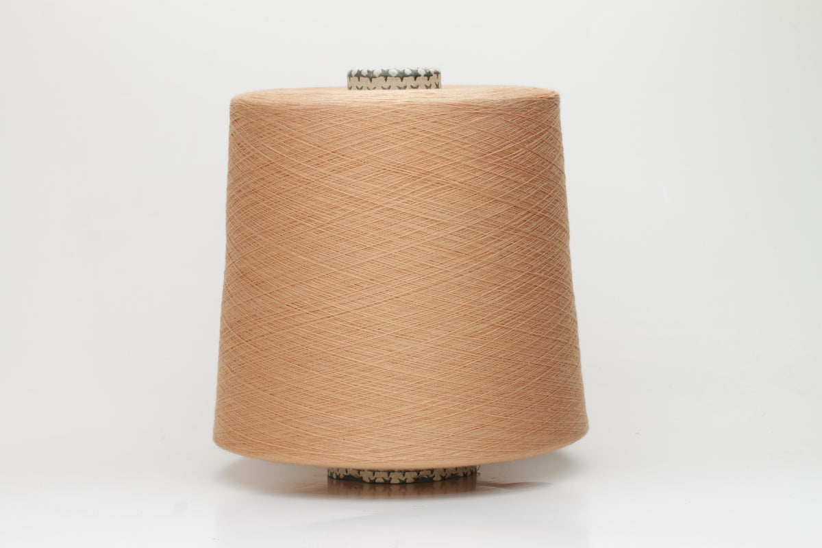 Close-up of finely spun Warm Peach Beige 100% cotton yarn, exhibiting a soft, matte sheen and a gentle two-ply twist. The sophisticated blend of khaki and beige fibers creates a nuanced, earthy tone.