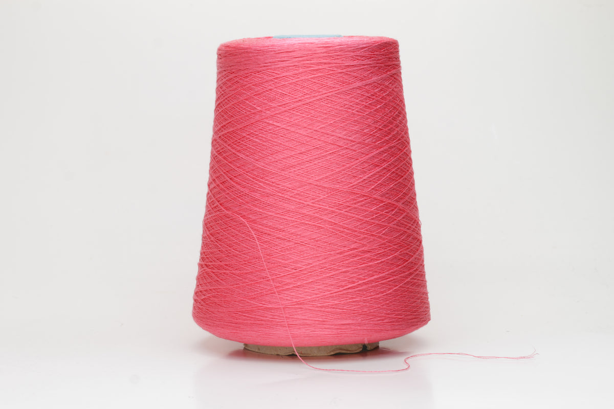 Close-up of a single ply, highly lustrous, smooth bright coral pink silk yarn with a subtle, delicate twist. The color is deep and vibrant.
