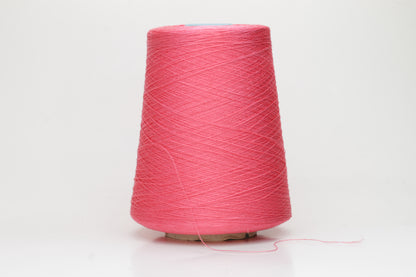 Close-up of a single ply, highly lustrous, smooth bright coral pink silk yarn with a subtle, delicate twist. The color is deep and vibrant.