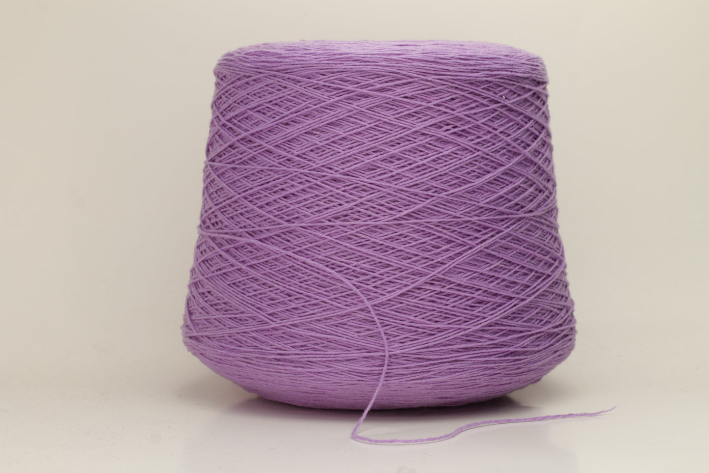 Vivid royal purple cashmere yarn, softly coiled, showcasing its fine 6-ply twist and subtle lustrous sheen, ideal for luxury textiles.