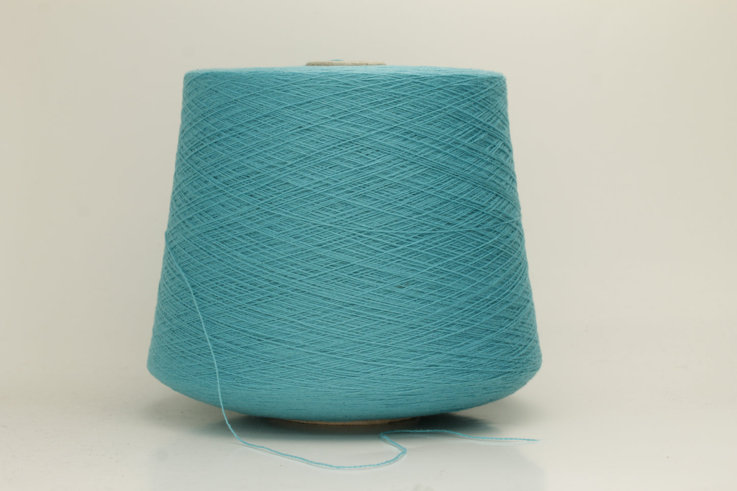 Close-up of a vibrant bright turquoise cashmere yarn hank, showcasing its fine, soft 2-ply twist and subtle, luxurious sheen.
