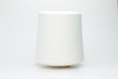 Close-up view of a creamy white, fluffy yarn strand with subtle sheen. The yarn shows a twisted ply construction and a dense, luxurious texture, hinting at its high cotton and cashmere fiber content.