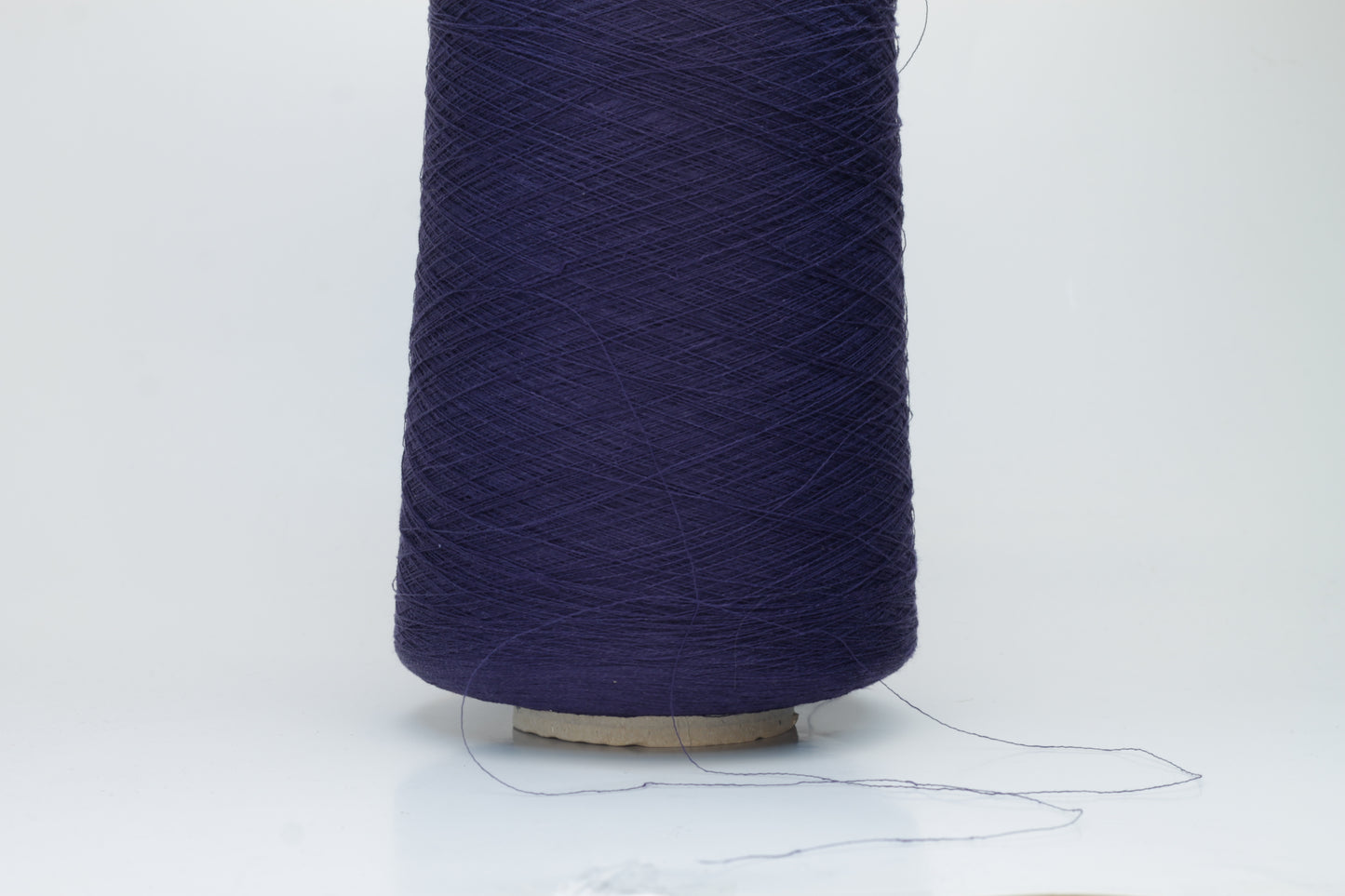Close-up of a smooth, single-ply navy linen blend yarn, with a fine, crisp texture and subtle, natural sheen.