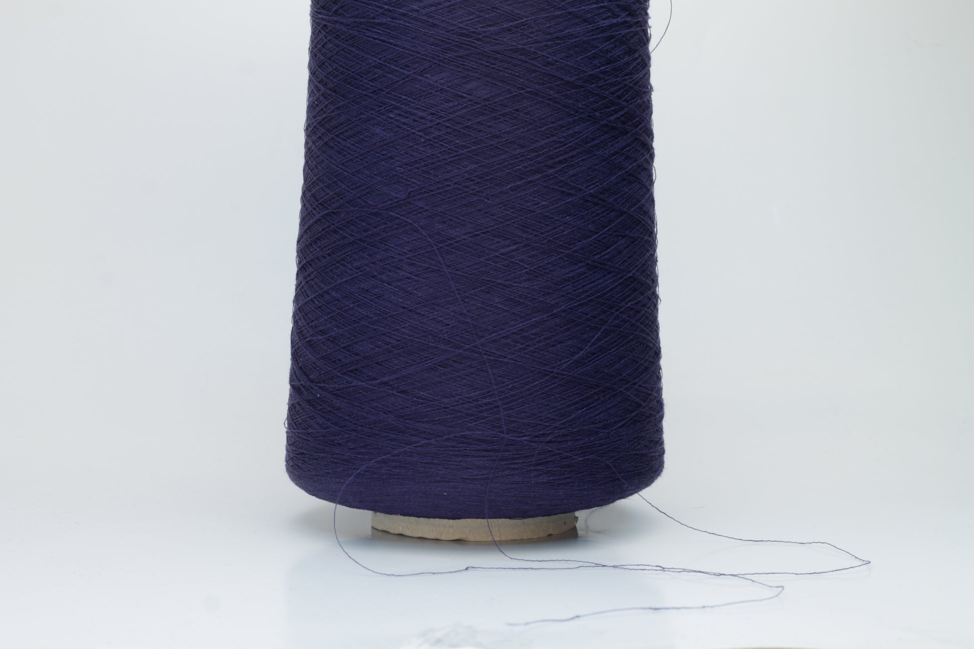 Close-up of a smooth, single-ply navy linen blend yarn, with a fine, crisp texture and subtle, natural sheen.
