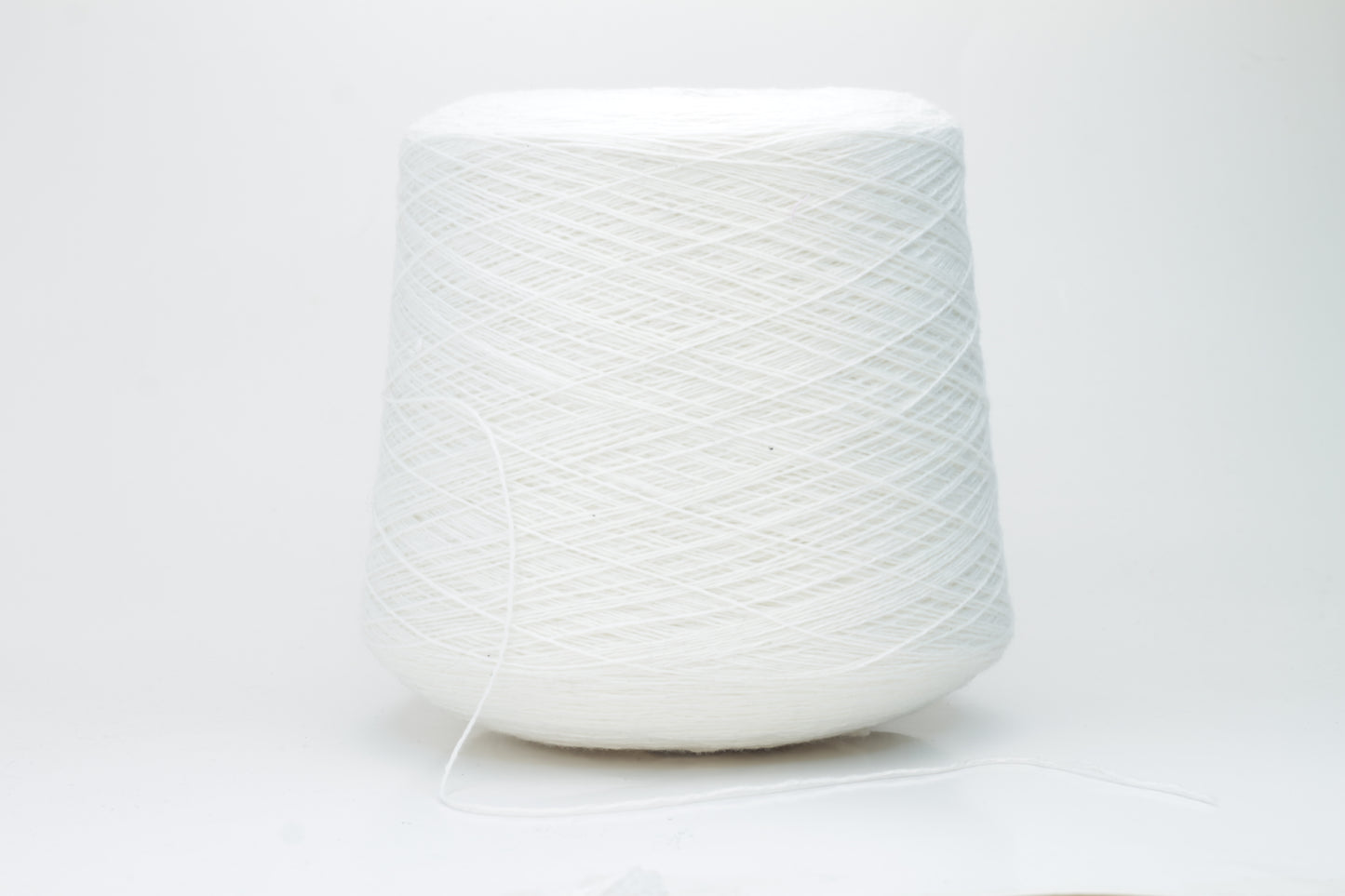 Close-up of a pure white cashmere yarn skein, showcasing its soft, slightly fluffy texture and subtle sheen with a gently twisted, fine two-ply structure.
