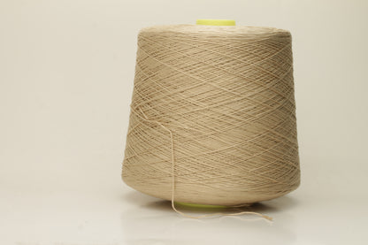 Close-up of a single strand of lustrous, fine-gauge beige silk and cotton yarn, showcasing its smooth, even twist and soft sheen.