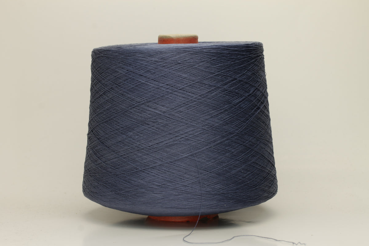 A tightly spun two-ply thread of very fine silk, exhibiting a deep, rich indigo blue hue with a natural, subtle shimmer under light.