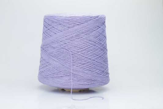Close-up of a single strand of matte lavender silk bourette yarn, showcasing its natural slub texture and soft, nubbly appearance, coiled gently.
