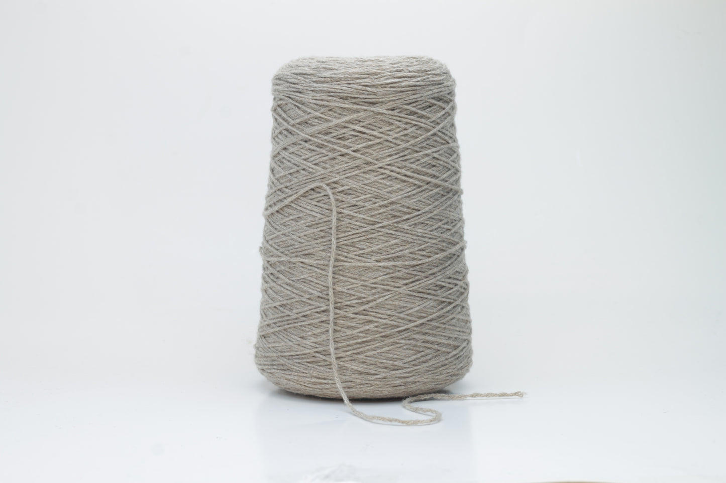 A finely spun, single-ply cashmere yarn in a rich, warm squirrel-brown, exhibiting a delicate halo of soft fibers and a subtle, natural sheen.