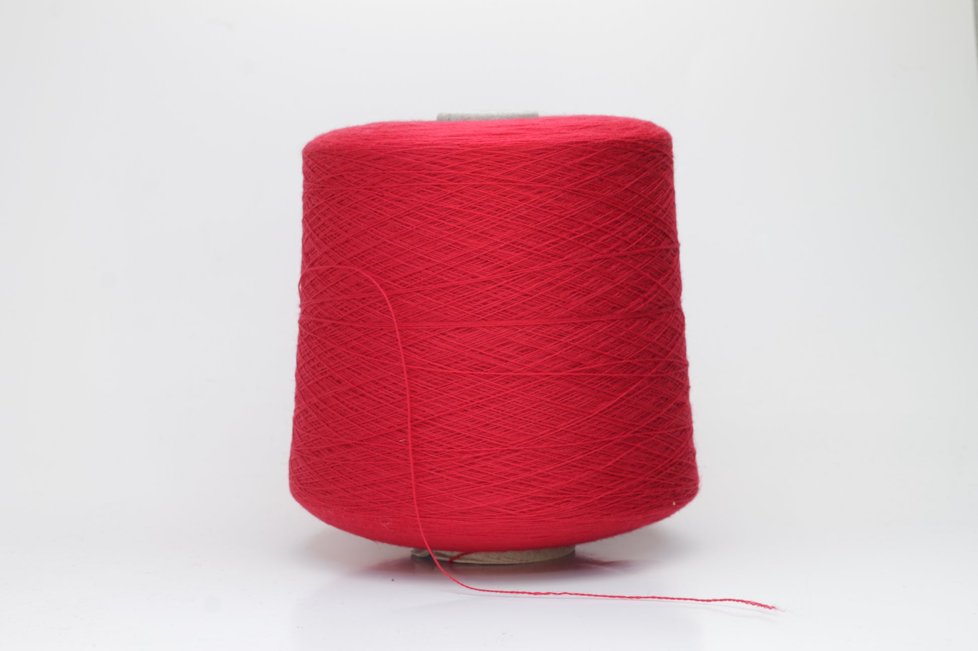 Close-up of luxurious Red Merino wool yarn, two-ply twist with a soft, subtle sheen, and fine, consistent thread structure.