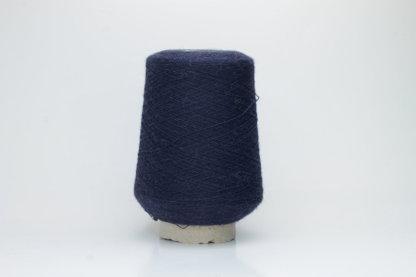 Close-up of Quipa Nm 2/28 Alpaca Merino yarn, showing its soft, slightly diffused fibers and a tight, even two-ply twist in a rich, dark navy hue.