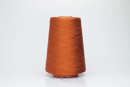 Close-up of a meticulously spun, single-ply bright orange silk yarn with a crisp, almost translucent quality and brilliant sheen.