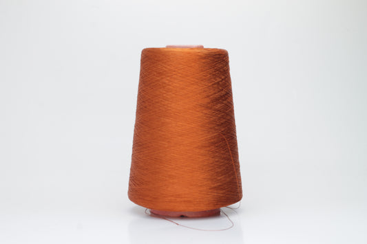 Close-up of a meticulously spun, single-ply bright orange silk yarn with a crisp, almost translucent quality and brilliant sheen.