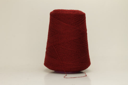 Close-up of fine 2-ply pure cashmere yarn in a rich, velvety burgundy red with subtle rosy undertones, showing its soft sheen and delicate fluff.